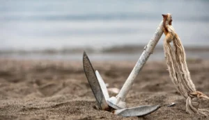 Anclas para embarcaciones tipo rezón sobre la arena de la playa.
