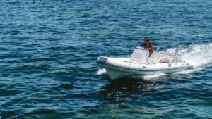 Embarcación semirrígida con consola de mando y motor fueraborda navegando en mar abierto.